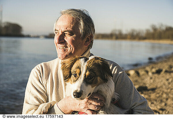 Happy man with pet dog on sunny day
