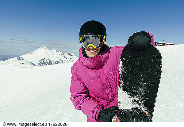 Happy man with snowboard on sunny day