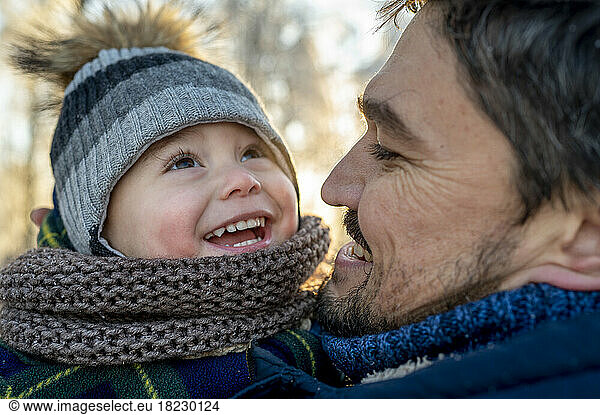 Happy man with son wearing warm clothing in winter