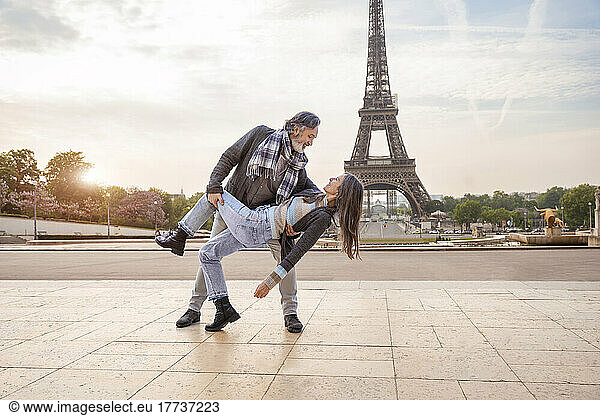 Happy mature couple dancing in front of Eiffel Tower  Paris  France