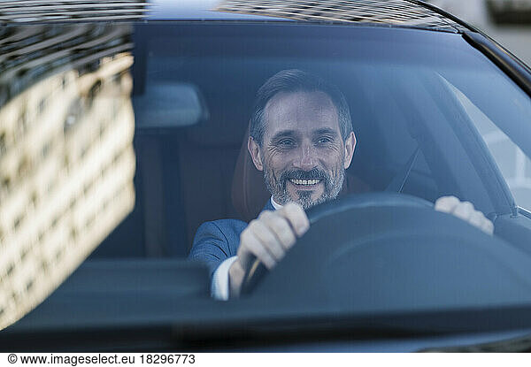 Happy mature man driving car