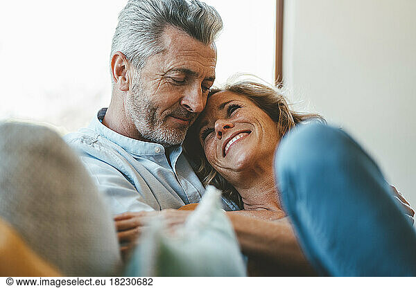 Happy mature man embracing woman at home