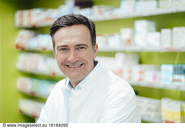 Happy mature pharmacist in pharmacy