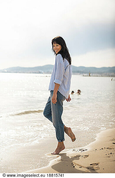 Happy mature woman standing near sea at beach