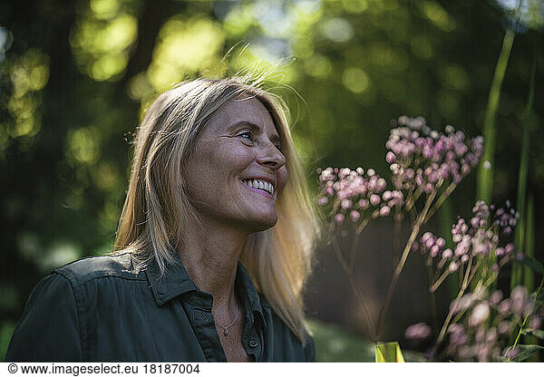 Happy mature woman with blond hair in garden