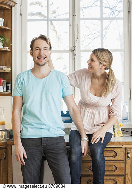 Happy mid adult couple spending leisure time in kitchen