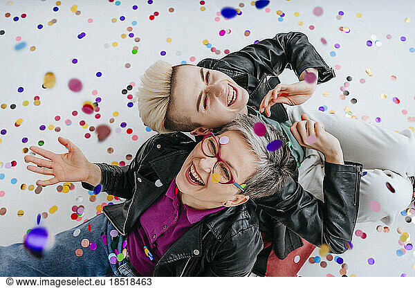 Happy mother and daughter having fun with confetti