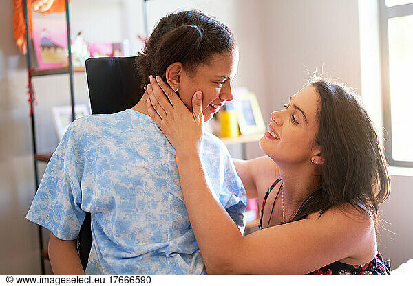 Happy mother and disabled daughter face to face