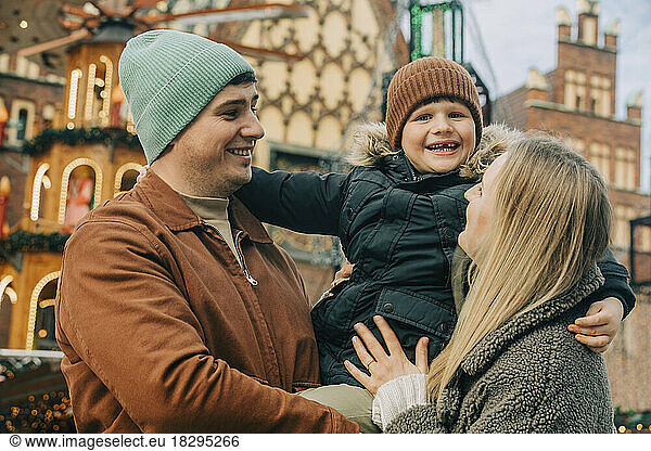 Happy mother and father enjoying with son at Christmas market