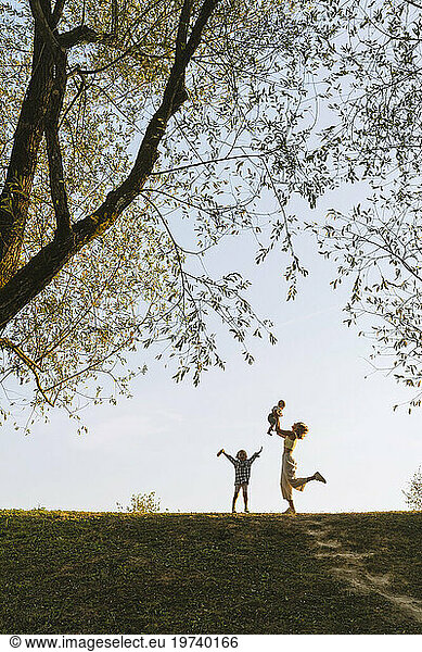 Happy mother playing with children at park