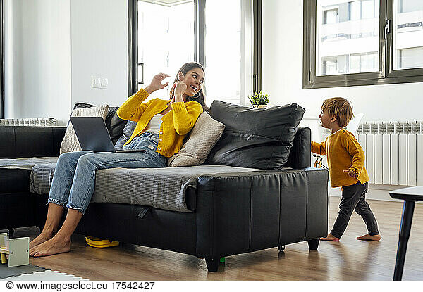 Happy mother playing with son in living room