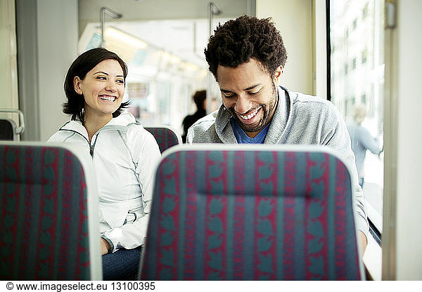Happy multi-ethnic couple travelling in bus