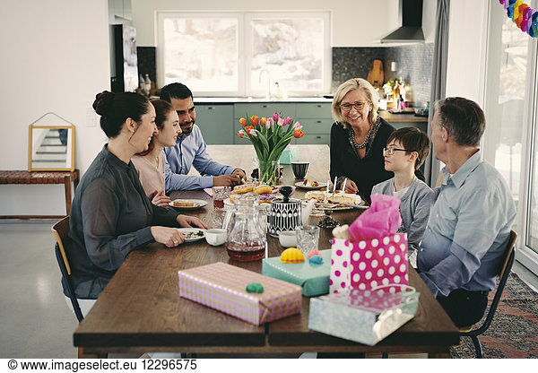 Happy multi-generation family enjoying at table during birthday party