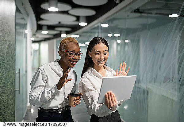 Happy multiethnic businesswomen making video call