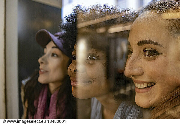 Happy multiracial friends seen through glass