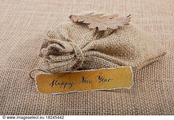 Happy new year written on a torn yellow paper on canvas