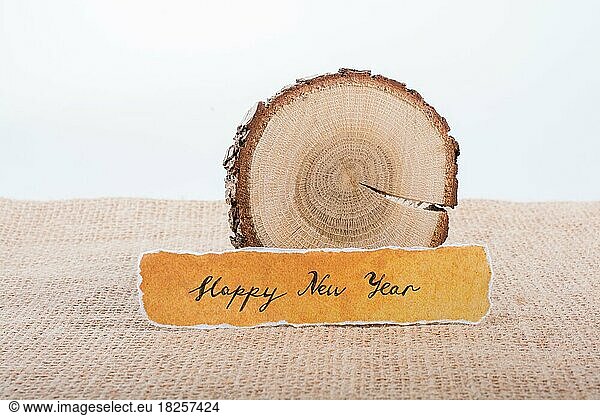 Happy new year written torn paper on piece of log