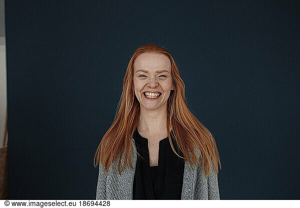 Happy redhead woman against blue background