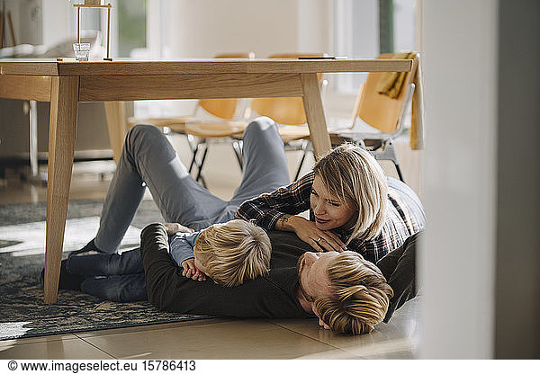 Happy relaxed family lying on the floor together at home