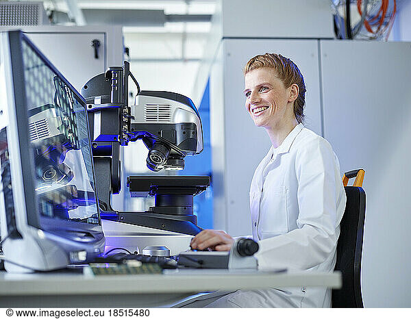 Happy scientist using desktop PC at E-Laboratory
