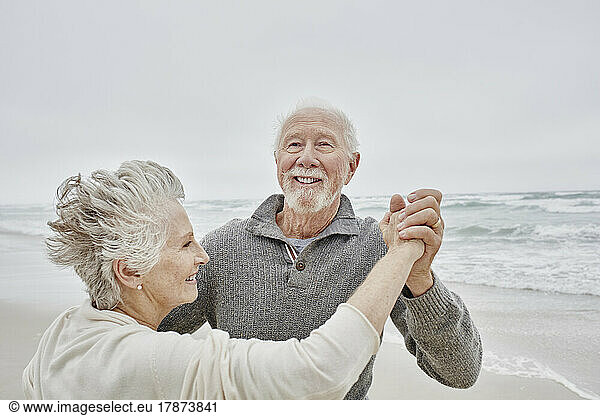 Happy senior couple dancing on the beach