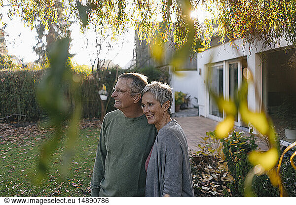 Happy senior couple in garden looking around
