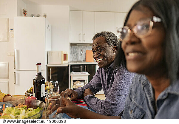 Happy senior man enjoying dinner with friends at home