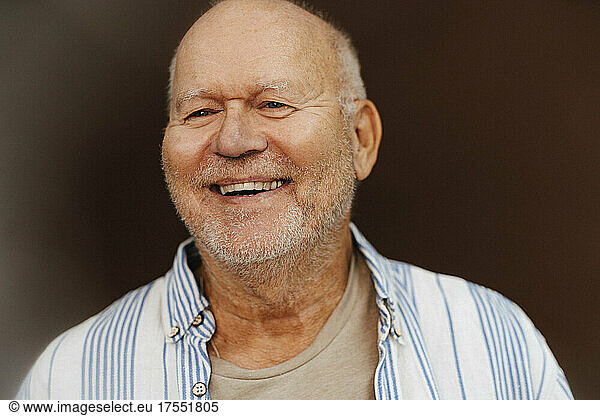 Happy senior man looking away in studio