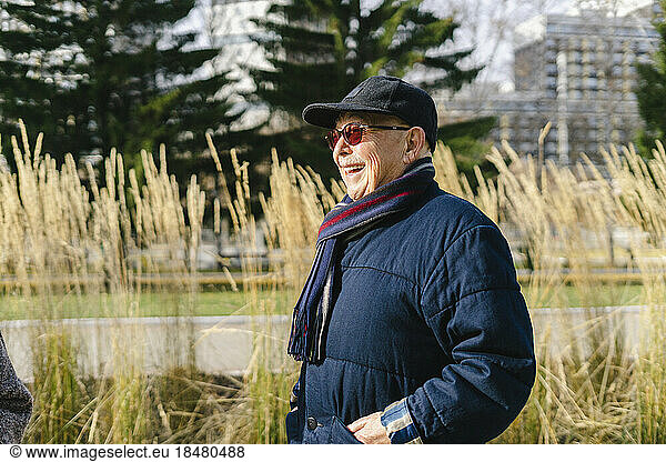 Happy senior man wearing jacket at park