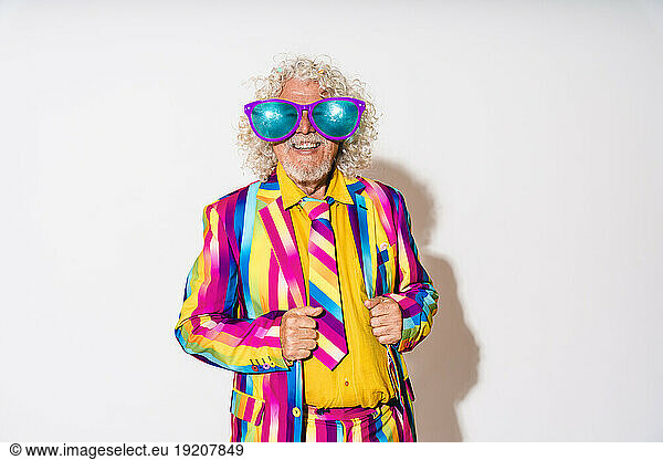 Happy senior man wearing oversized sunglasses against white background
