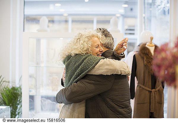 Happy senior woman hugging husband in jewelry store