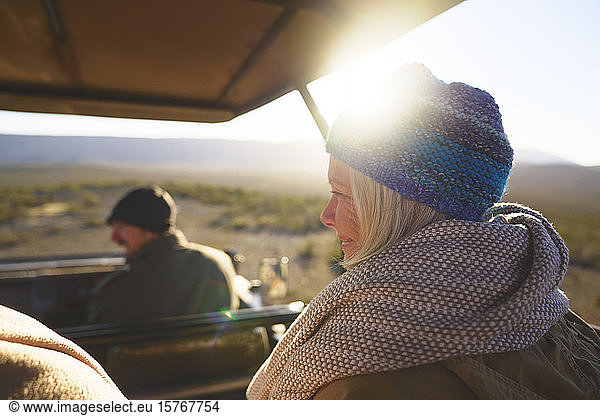 Happy senior woman riding in sunny safari off-road vehicle