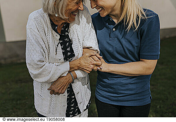 Happy senior woman with female caregiver