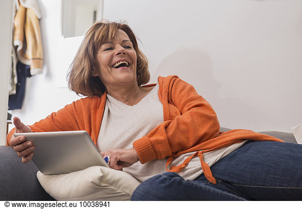 Happy senior woman working a digital tablet  Munich  Bavaria  Germany
