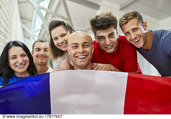 Happy sports fans with French Flag in stadium