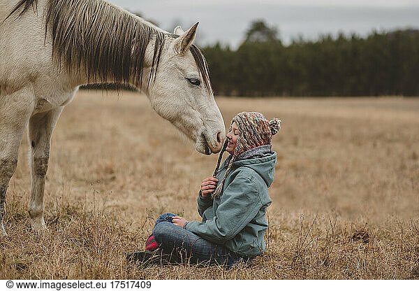 Happy teen girl in front of horse