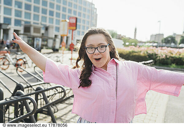Happy teenage girl with down syndrome dancing on sunny day