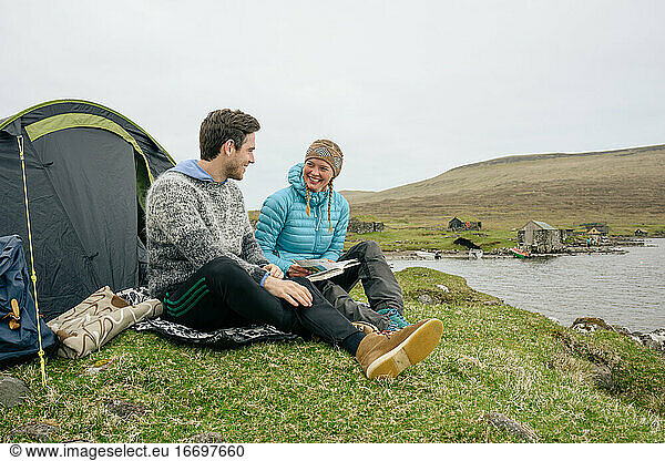 Happy tourists with book resting on coast