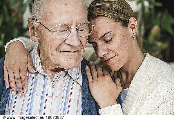 Happy woman embracing senior man at home