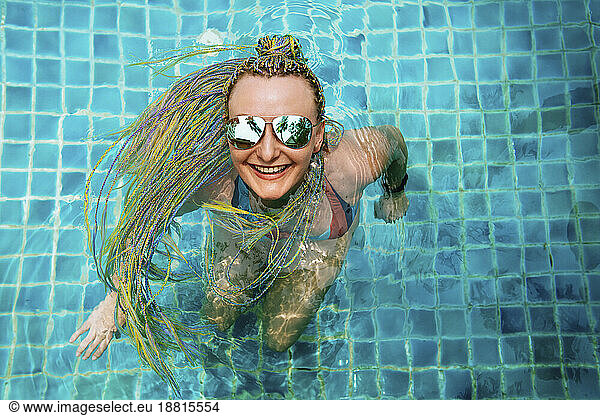 Happy woman enjoying and swimming in pool