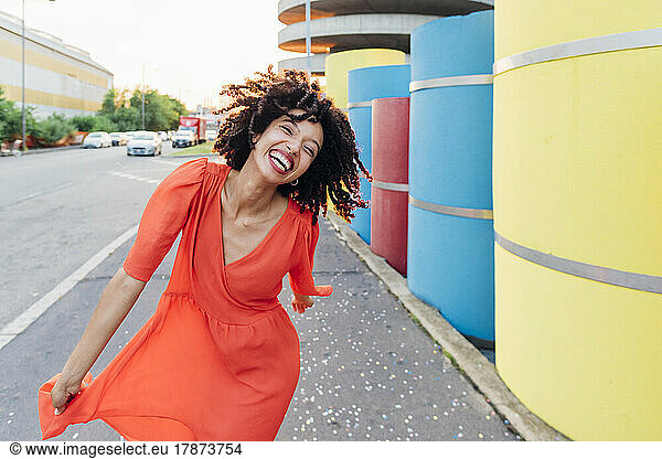 Happy woman enjoying dance by multi colored pipes