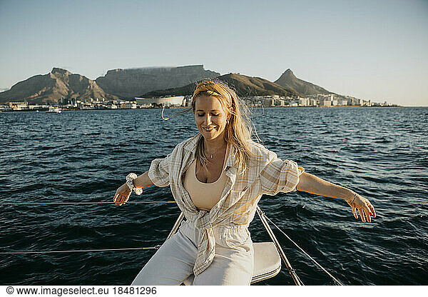 Happy woman enjoying on boat in sea at weekend