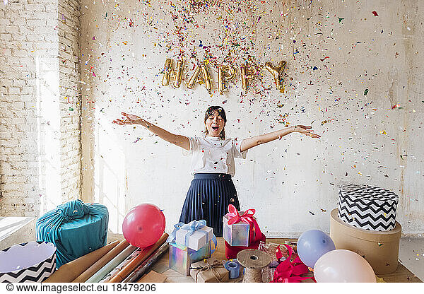 Happy woman enjoying under falling confetti