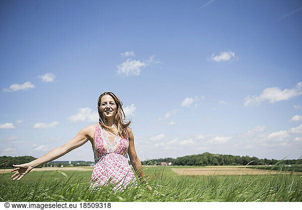 Happy woman enjoying with arms outstretched on meadow in the countryside  Bavaria  Germany