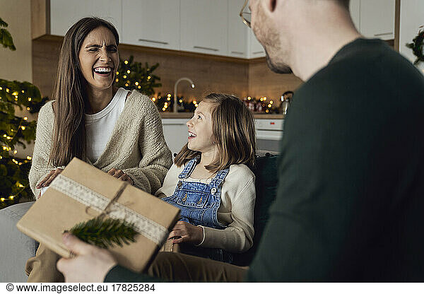 Happy woman enjoying with daughter and man in living room