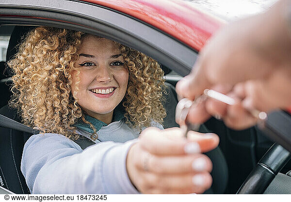 Happy woman giving car keys to personal valet