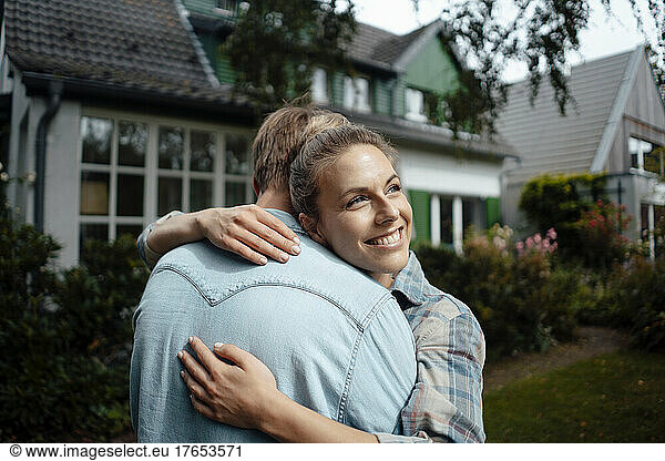 Happy woman hugging boyfriend at backyard