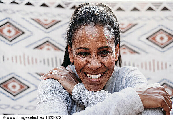 Happy woman in front of patterned backdrop