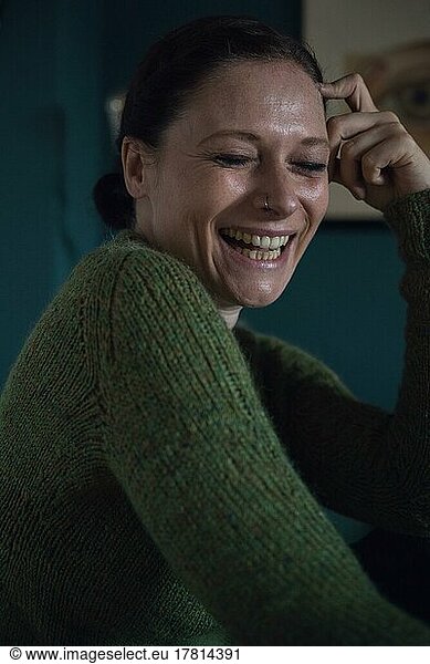 Happy woman  interior shot of a woman in a knitted wool jumper  portrait