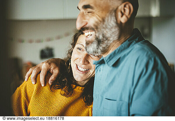 Happy woman leaning on man shoulder at home
